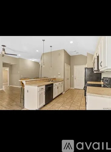 A kitchen with white cabinets and a wooden island.