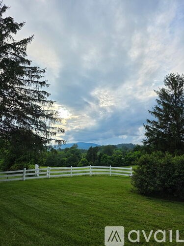 A white fence encloses a lush green field.