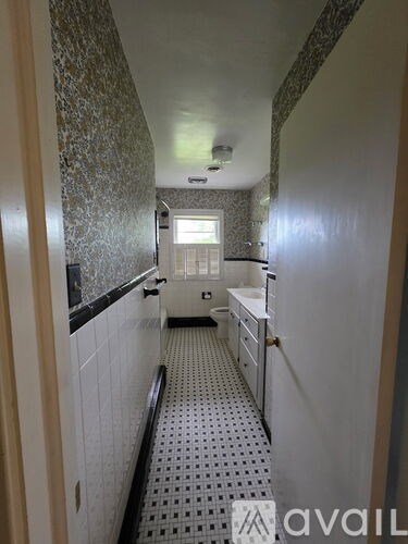 A bathroom with a tiled floor and walls.