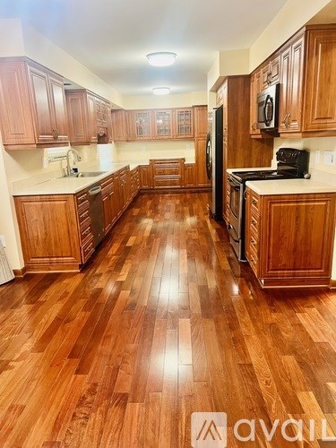A kitchen with wooden floors and cabinets.