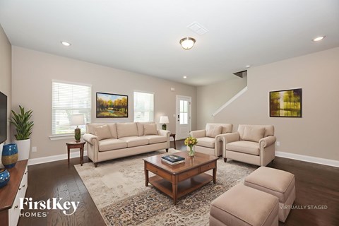 A living room with a brown coffee table and two beige couches.