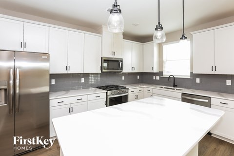 A modern kitchen with a stainless steel refrigerator and white countertops.