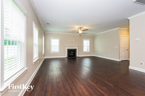 A spacious living room with wood floors and a fireplace.