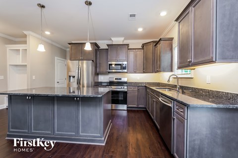 A modern kitchen with dark wood cabinets and stainless steel appliances.