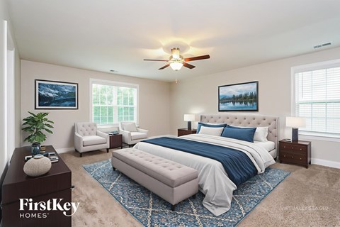 A bedroom with a large bed and a ceiling fan.