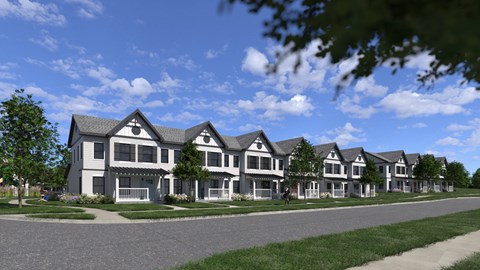 A row of houses with a blue sky and clouds in the background.