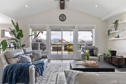 A living room with a grey couch and a blue throw blanket.