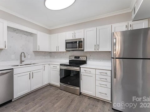 A kitchen with a stainless steel refrigerator, oven, and microwave.
