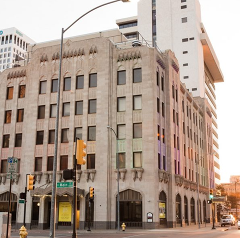 A street view of a building with a traffic light in front of it.