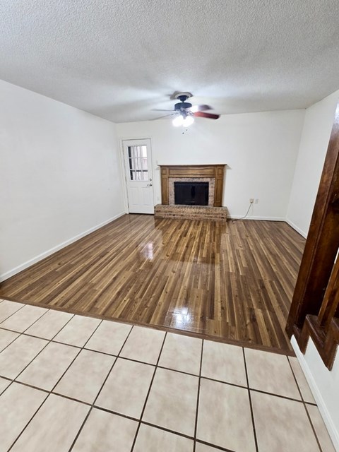 A room with a fireplace and a ceiling fan.