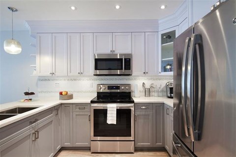 A modern kitchen with a stainless steel refrigerator and oven.