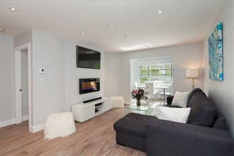 A modern living room with a grey couch and a white coffee table.