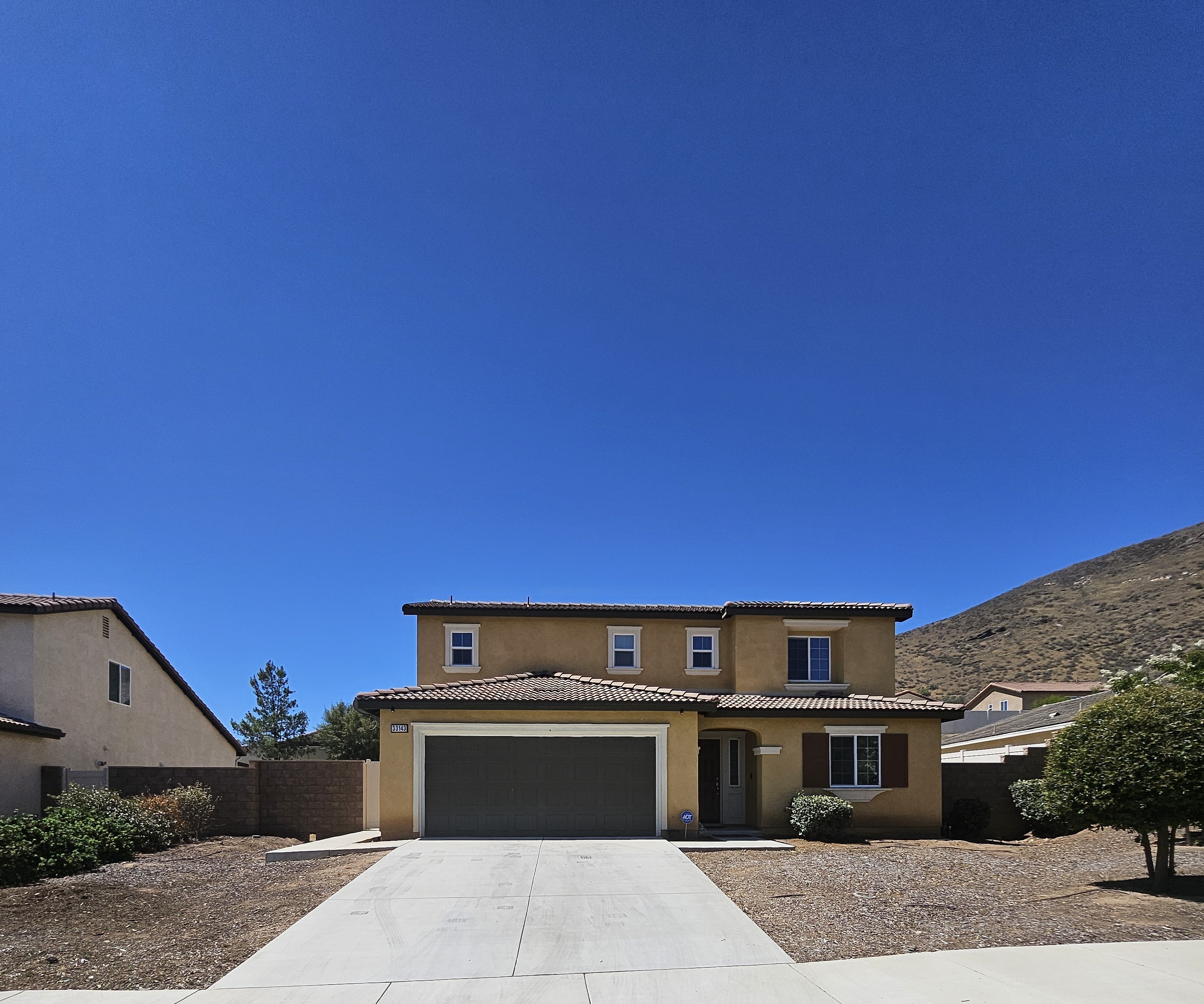 A house with a garage and a driveway in front of it.