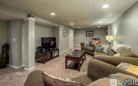 A living room with a brown couch and a wooden coffee table.