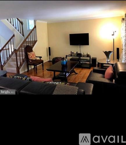 A living room with a couch, a chair, a coffee table, and a television.