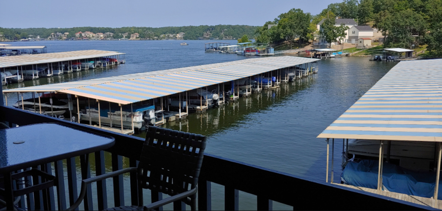 A view of a dock with boats and buildings in the background.