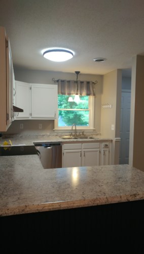 A kitchen with granite countertops and white cabinets.