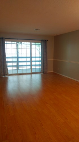 A room with wooden floors and a large window.