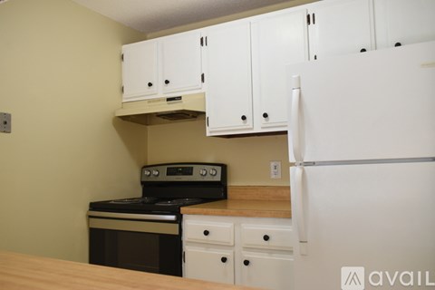 A kitchen with white cabinets and a black stove top oven.