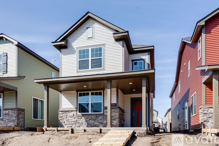 A modern house with a stone pillar in front.