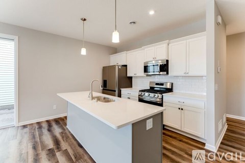 A kitchen with white cabinets and a wooden floor.