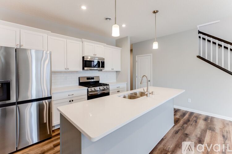 A modern kitchen with stainless steel appliances and white countertops.