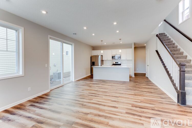 A spacious living room with a staircase on the right side.