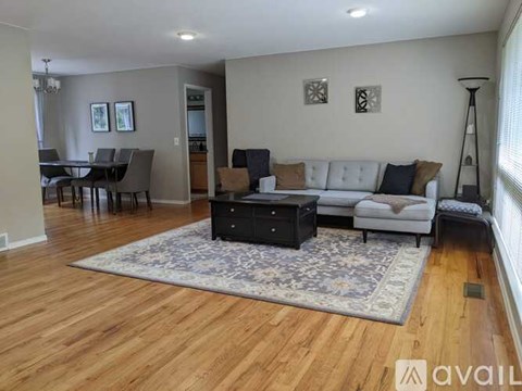A living room with a white couch and a rug.