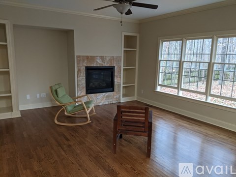 A living room with a green chair and a wooden table.