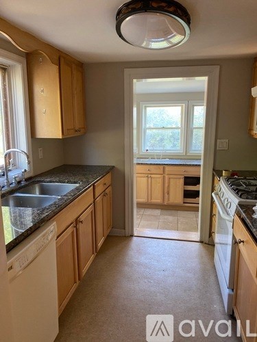 A kitchen with wooden cabinets and a black countertop.