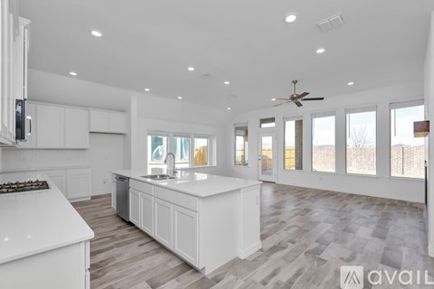 A spacious kitchen with white cabinets and a central island.