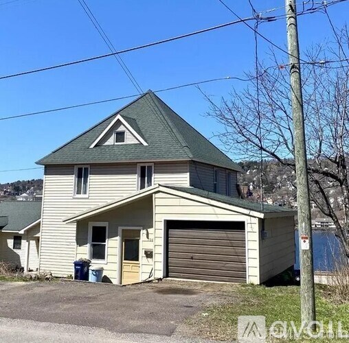 A two-story house with a garage and a driveway.
