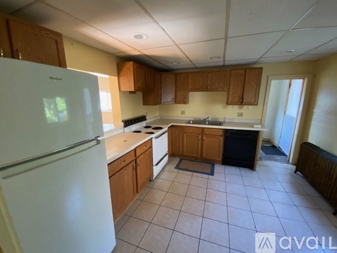 A kitchen with a white refrigerator and wooden cabinets.
