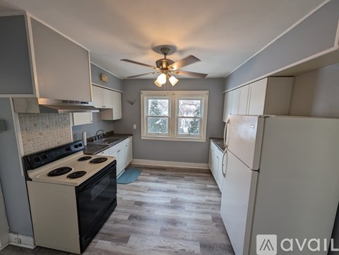 A kitchen with a black stove top oven and a white refrigerator.
