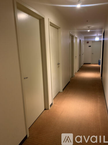 A long hallway with doors on both sides and a carpet on the floor.