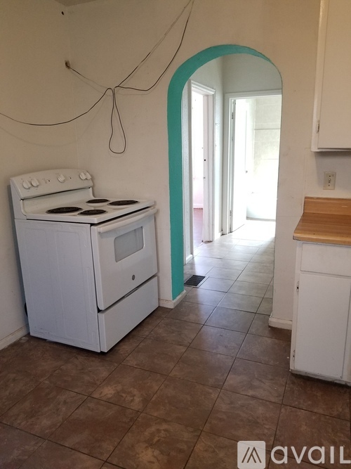 A white stove in a kitchen with a tile floor.