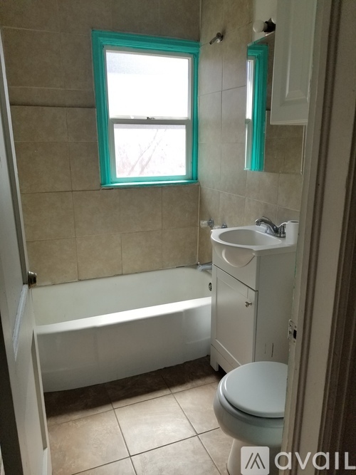 A bathroom with a tub, toilet and sink.