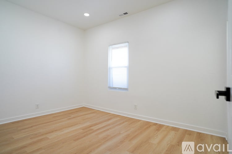 A room with wooden flooring and a window.