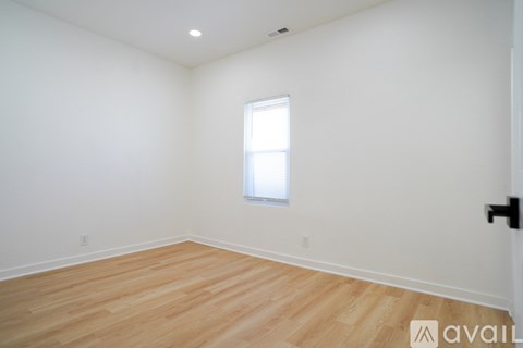 A room with wooden flooring and a window.