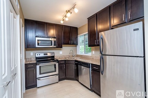A kitchen with black cabinets and a white refrigerator.