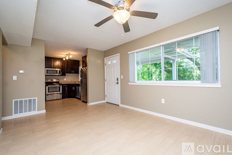 A spacious living room with a kitchen in the background.