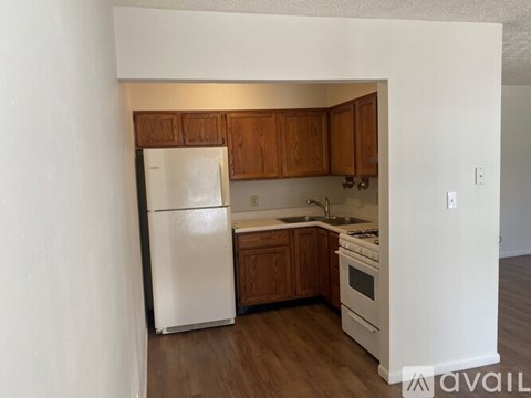 A kitchen with wooden cabinets and white appliances.