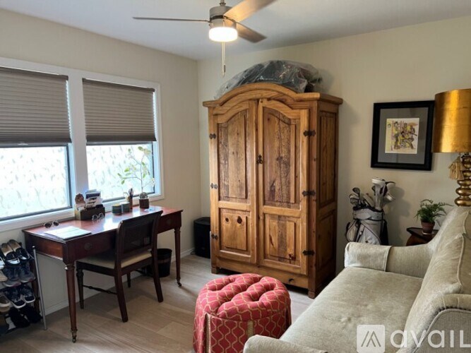 A room with a desk, chair, and a cabinet.