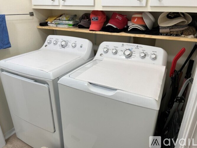 Two white front loading washing machines in a small laundry room.