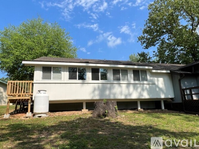 A house with a porch and a tree stump in front.