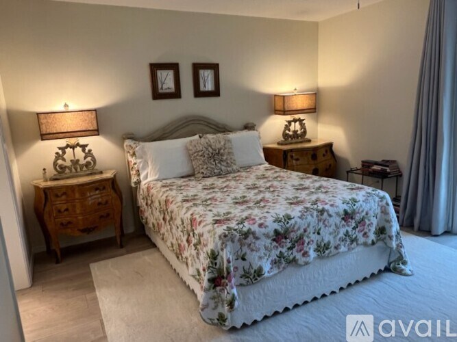 A bedroom with a large bed and two lamps on either side of the bed.