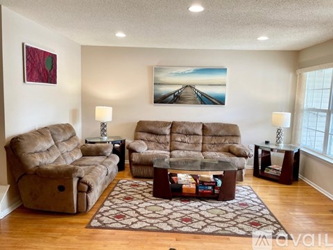 A living room with a large painting of a bridge over water.