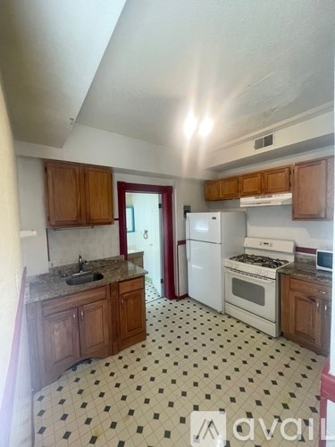 A kitchen with white appliances and wooden cabinets.