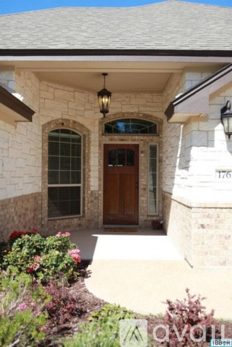 A house with a brown door and a number 176 on the wall.