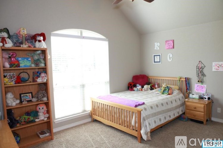 A child's bedroom with a bed, dresser, and toy shelf.